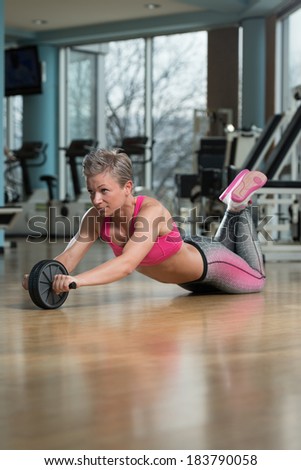 Beautiful Woman Using An Ab Wheel - Female Exercising Fitness Workout For Abdominal