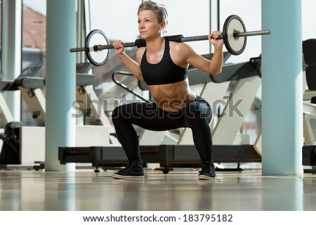 Woman Doing Squats - Beautiful Fit Female Doing Barbell Squats In The Gym