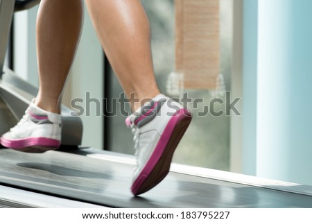 Fitness Woman Running On Treadmill - Close-Up Of Female Legs Running On Treadmill - Blurred Motion
