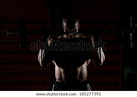 Bodybuilder Performing Biceps Curls With A Barbell