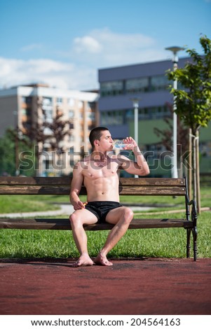 Young Muscular Men Drinking A Water Bottle
