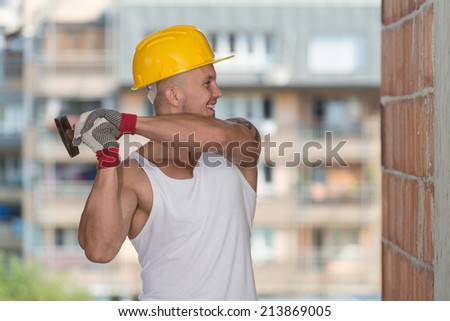 A Handsome Construction Man Using A Hammer To Nail Together Wood