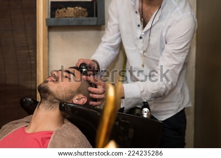 Smiling Man Having His Hair Washed At Hairdresser\'s - Hairstylist Hairdresser Washing Customer Hair - Young Man Relaxing In Hairdressing Beauty Salon