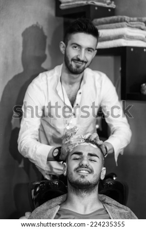 Portrait Of Male Client Getting His Hair Washed - Hairstylist Hairdresser Washing Customer Hair - Young Man Relaxing In Hairdressing Beauty Salon