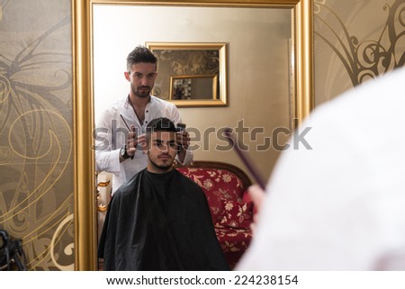 Reflection Of Hair Stylist Doing Hair Style - Handsome Young Hairdresser Giving A New Haircut To Male Customer At Parlor