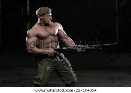 Man Drawing Machine Gun In Self Defense - Standing In Abandoned Building Wearing Green Pants