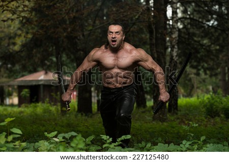 Man Drawing Ancient Sword In Self Defense - Standing In Forest Wearing Leather Pants