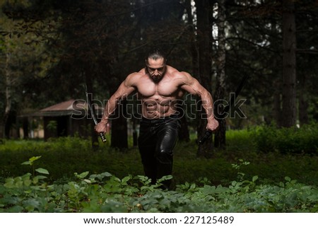 Mature Man In Action With Sword - Standing In Forest Wearing Leather Pants
