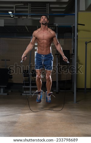 Young Man In Gym Is Jumping Rope