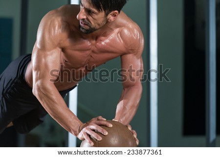 Attractive Male Athlete Performing Push-Ups On Medicine Ball