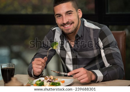 Handsome Man Eating At A Restaurant And Looking Happy
