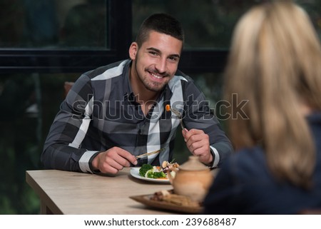 Friends Eating At A Restaurant And Looking Happy