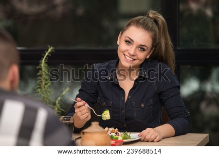 Friends Eating At A Restaurant And Looking Happy