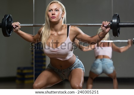 Young Woman Performing Barbell Squats - One Of The Best Body Building Exercise For Legs