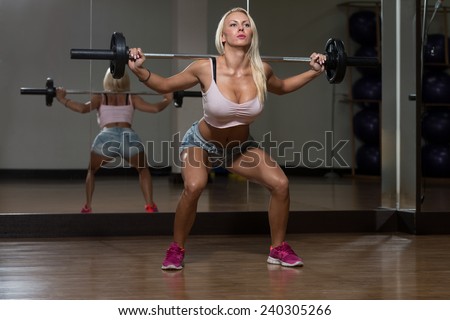 Young Woman Performing Barbell Squats - One Of The Best Body Building Exercise For Legs