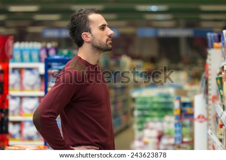 Handsome Young Man Shopping For Fruits And Vegetables In Produce Department Of A Grocery Store - Supermarket - Shallow Deep Of Field
