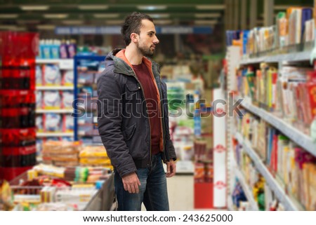 Handsome Young Man Shopping For Fruits And Vegetables In Produce Department Of A Grocery Store - Supermarket - Shallow Deep Of Field