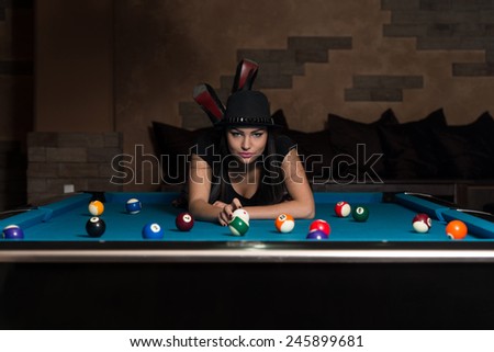 Portrait Of A Young Woman Lying On The Table And Playing Billiards