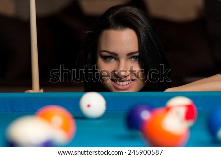 Young Woman Lining To Hit Ball On Pool Table