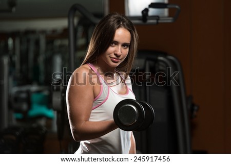 Young Woman Doing Heavy Weight Exercise For Biceps With Dumbbells