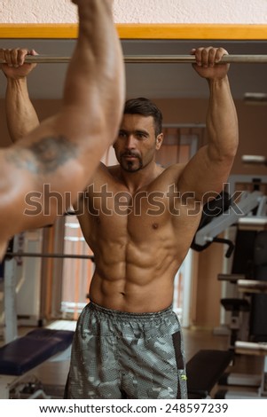 Muscular Man Flexing Abdominal Muscles Abs In A Health Club