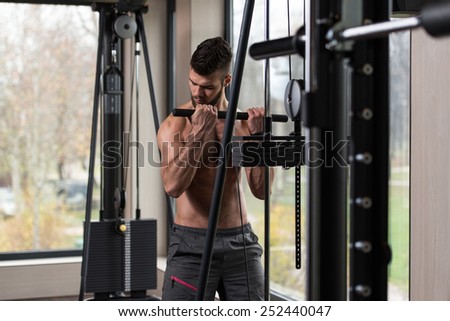 Young Handsome Man Exercise Biceps On Cable Machine