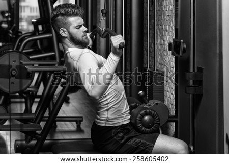 Young Man Doing Heavy Weight Exercise For Back In Gym