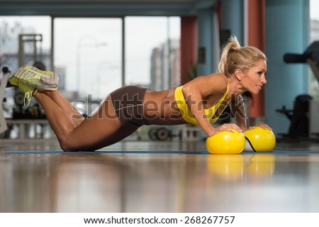 Middle Age Woman Doing Pushups On Yellow Balls As Part Of Bodybuilding Training