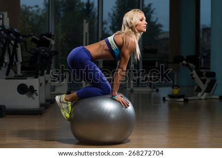 Middle Age Woman Exercising With An Exercise Ball In Fitness Club