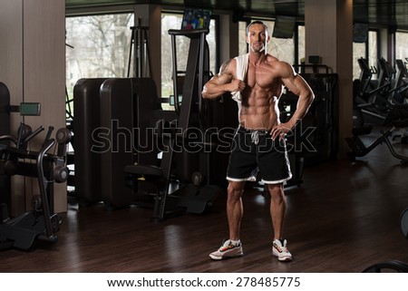 Handsome Muscular Man With A Towel On His Shoulders In Modern Fitness Center