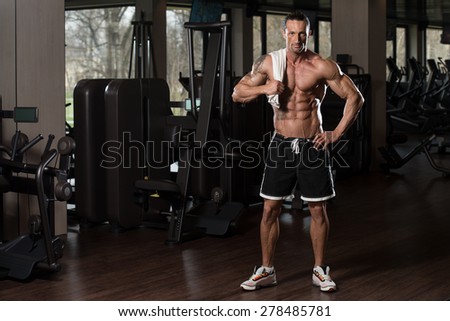 Handsome Muscular Man With A Towel On His Shoulders In Modern Fitness Center