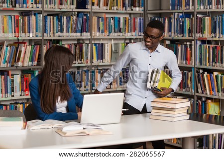 Handsome Male Student Asking  For Studying Together - Young Students Working Together In The Library - Shallow Depth Of Field