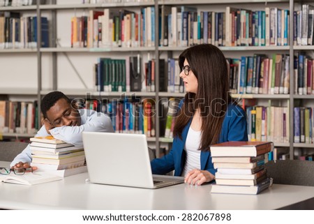 Sleeping Student Sitting And Leaning On Pile Of Books In College - Shallow Depth Of Field