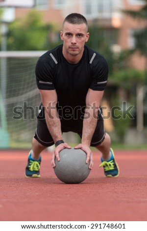 Young Man Outdoors Performing Push Ups On Medicine Ball Bodybuilding Exercise