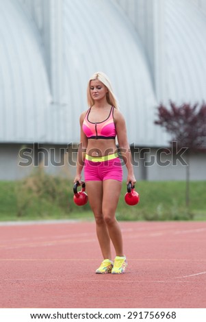 Young Woman Working Out With Kettle Bell Exercise Outdoor