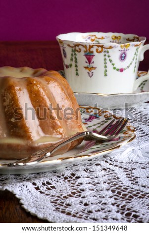 Mini Pound Cake - Almond lemon drizzle cake on old pictures coffee cup, side plate on lace, purple background