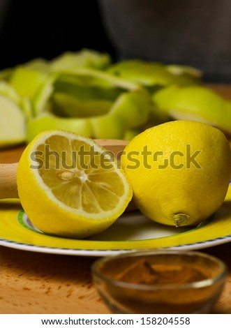 Lemon cut on yellow plate, peeled apples, apple skin, cinnamon powder