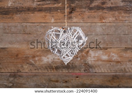 Heart shape white christmas wreath from natural painted twigs on old wooden rustic background