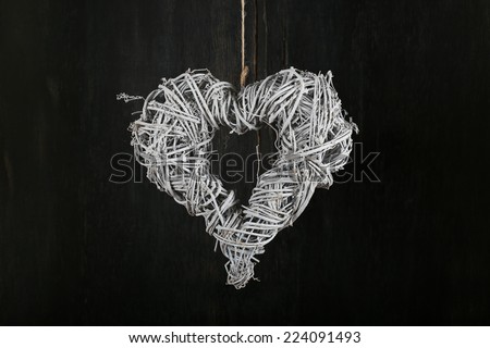 Heart shape white christmas wreath from natural painted twigs on old dark rustic background