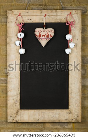 Merry Christmas and Happy New Years chalkboard blackboard tin bells and heart decoration restaurant vintage menu design on painted reclaimed wooden frame, light brown brick wall, copy space