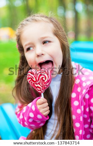 child eating pink candy