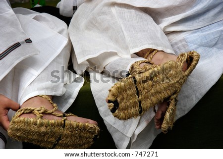 Two young men wearing traditional, Japanese straw sandals prior to the start of a large parade / festival in Kyoto, Japan.
