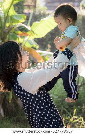 Soft focus portrait of happy loving mother and her baby outdoors,Beautiful young mother holds a baby