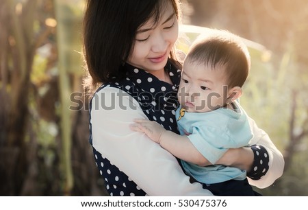 Portrait of happy loving mother and her baby outdoors,Beautiful young mother holds a baby