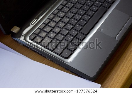 laptop with paper on desk
