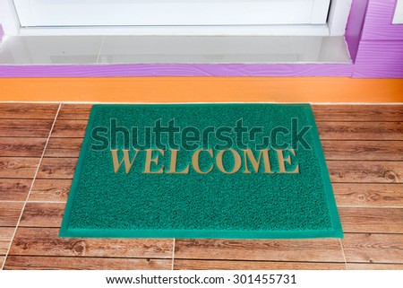 green welcome mat  at the door