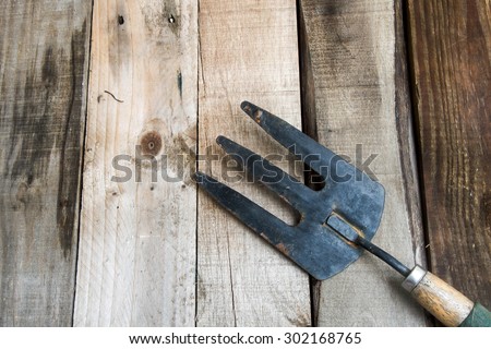 old garden fork on wood background
