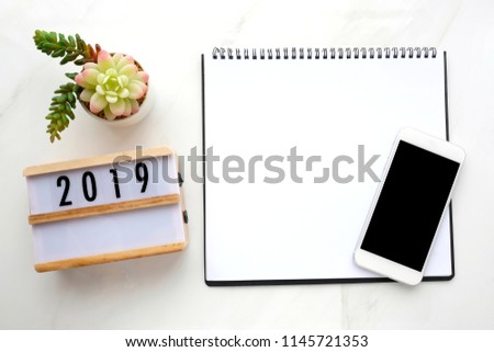 2019 wood box, blank notebook paper, smart phone with blank screen on white marble background, 2019 new year mock up, template, flat lay