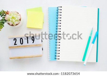2019 on wood box, blank notebook paper on white marble table background, 2019 new year mock up, template with copy space for text, top view