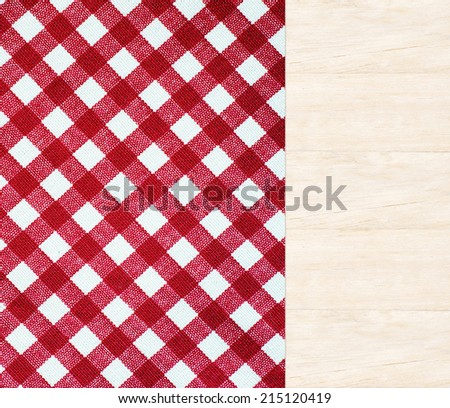 Wooden table covered with red checked tablecloth, top view, background, display, template